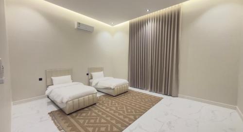 a bedroom with two beds and a rug at شقق ميلا الباحة الفاخرة in Al Baha