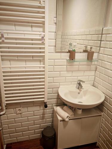 a white bathroom with a sink and a mirror at Kuća za odmor Iva in Lič