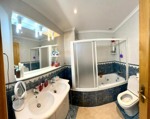 a bathroom with a tub and a sink and a toilet at Quarto em Bragança in Bragança