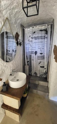 a bathroom with a sink and a shower curtain at Cuevita El Abrigo - 1 dormitorio in Lomo de Arico