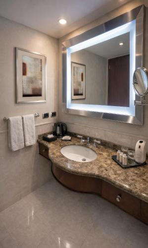 a bathroom with a sink and a large mirror at Regal Pacific Puerto Madero in Buenos Aires