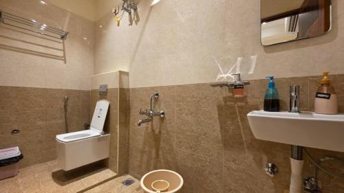 a bathroom with a shower and a toilet and a sink at Kanchi Crown Residency in Kanchipuram