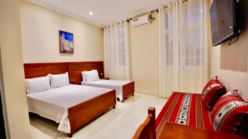 a hotel room with two beds and a television at Marhaba Hotel Casbah in Kasbah