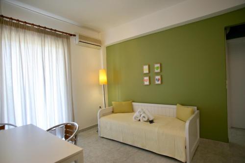a living room with a white couch in a green wall at Long View Apartments in Porto Heli