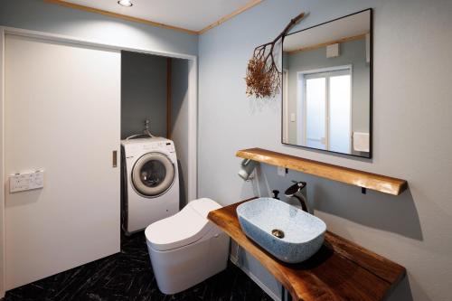 a bathroom with a sink and a washing machine at New Field Chalet 白馬 in Hakuba