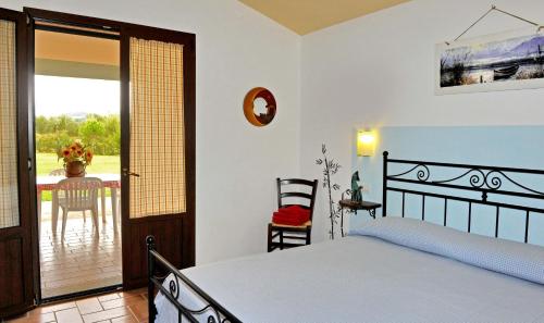 a bedroom with a bed and a sliding glass door at Agriturismo Bocci in Castiglione della Pescaia