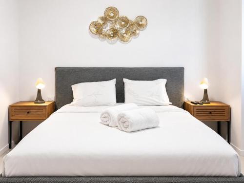 a bedroom with a white bed with towels on it at Apartments4you Queen in Bat Yam