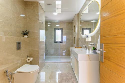 a bathroom with a toilet and a sink and a shower at Cavella Apart Hotel in Monsef in Al Ḩulwah