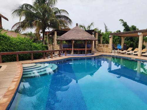 a large swimming pool with chairs and a gazebo at Résidence Tina 1 in Ngalou Sessène