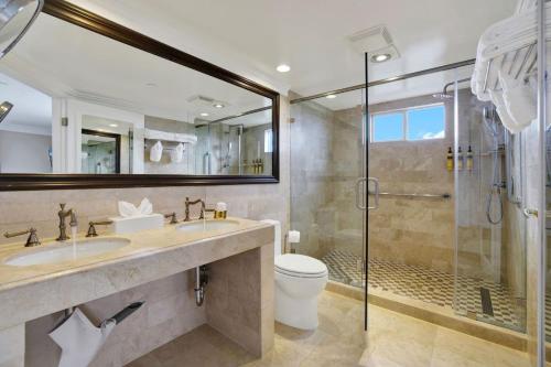 a bathroom with a shower and a toilet and a sink at Best Western Plus Sunset Plaza Hotel in Los Angeles
