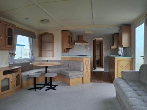 a kitchen and living room with a table and a couch at Atlas Florida in Ingoldmells
