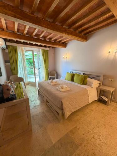 a bedroom with a large bed with green pillows at Relais dei Molini - Villa dei Molini in Castagneto Carducci