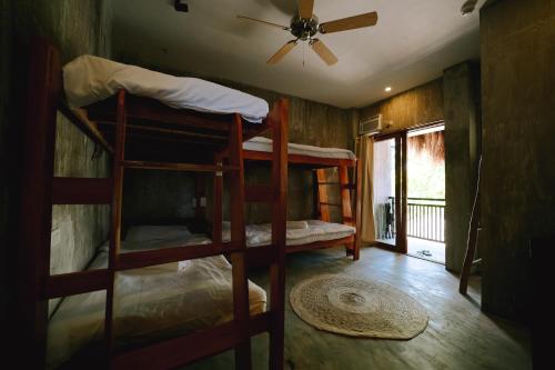 two bunk beds in a room with a ceiling fan at Casa Felipe in General Luna