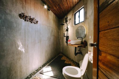 a bathroom with a toilet and a sink and a mirror at Casa Felipe in General Luna