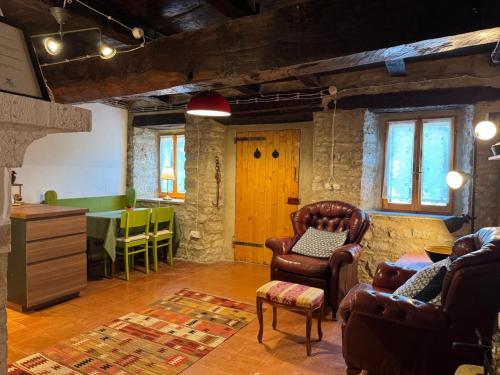 a living room with leather chairs and a table at Il Rifugio - Cottage With Pool in Toano