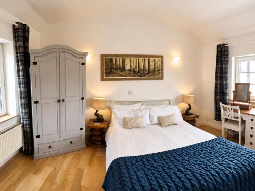 a bedroom with a large bed with a blue blanket at Bowland Breaks - Cobble View Cottage Cosy Retreat, Parking, Near Wedding Venues, Village Location with 3 great pubs in Waddington