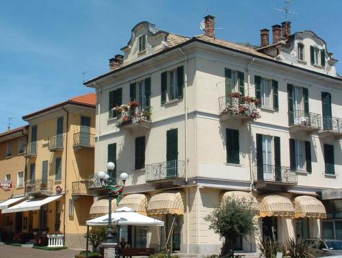 a large white building with flower boxes on the windows at Residence Cosy Baveno in Baveno