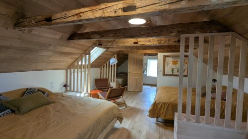 a bedroom with two beds and a chair in a room at L'Estive du Claux in Le Claux