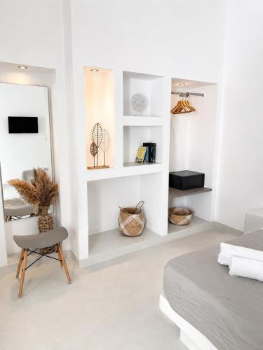 a bedroom with a bed and a chair and a mirror at Fira Centrum White in Fira