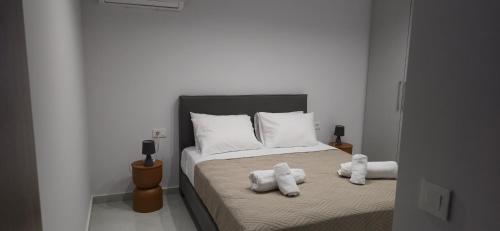 a bedroom with a bed with two stuffed animals on it at Kos Cozy Home in Platánion