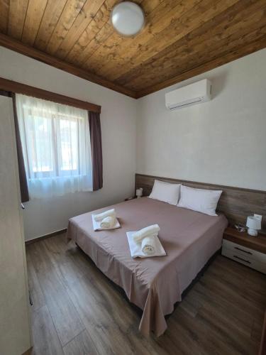 a bedroom with a large bed with two towels on it at Alyki Stone Houses 1 in Alyki