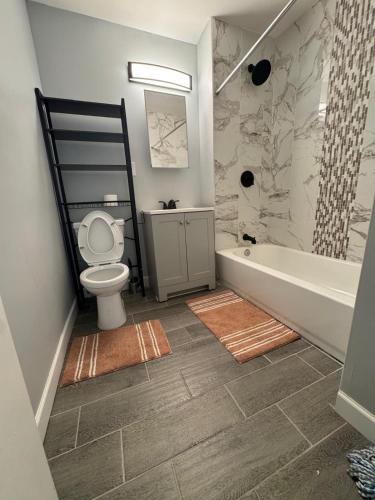 a bathroom with a tub and a toilet and a sink at Hillside Appartment #2 in Newark