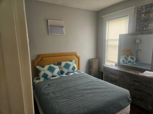 a bedroom with a bed with a dresser and a mirror at Hillside Appartment #2 in Newark