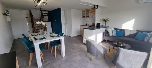 a kitchen and a living room with a table and chairs at L'Ophelia Duplex Dernier étage balcon Centre climatisation in Sète