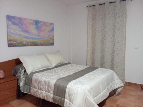 a bedroom with a bed and a painting on the wall at ESCAPADA RELAX in Arroyo Frio