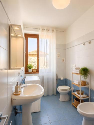 a bathroom with a sink and a toilet and a window at La Terrazza delle Colline in Brunello