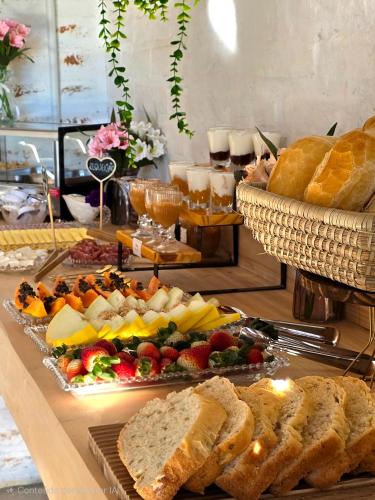 a buffet with bread and different types of food at Chalés Vila do Moinho in Monte Verde