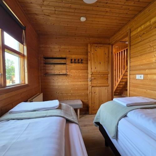 a bedroom with two beds in a wooden cabin at Akureyri Cottages in Akureyri