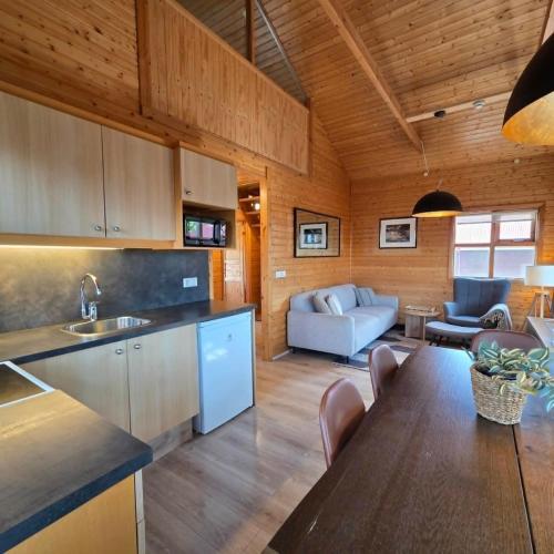 a kitchen and living room with a table and a couch at Akureyri Cottages in Akureyri