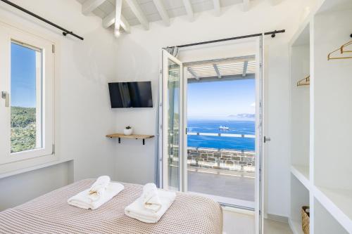a bedroom with a bed and a view of the ocean at Villa Aerys in Skopelos Town