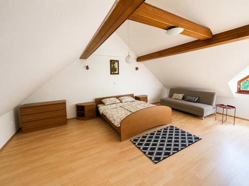a bedroom with a bed and a couch in a attic at Digital Detox House Haloze in Podlehnik