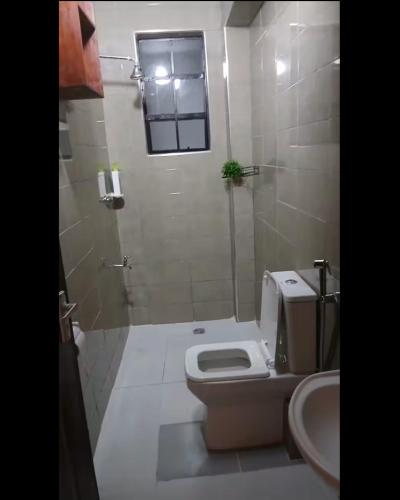 a bathroom with a toilet and a sink at Imani staycations Diani in Diani Beach
