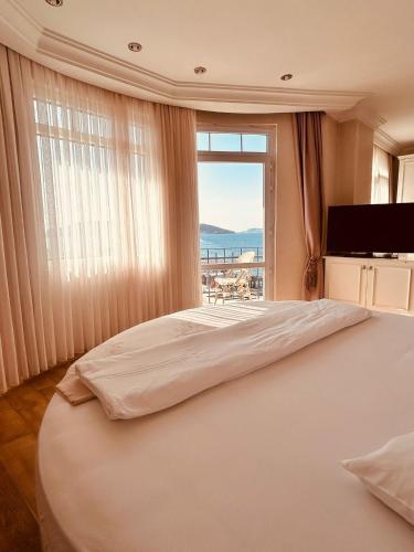 a bedroom with a large bed with a large window at Buyukada Princess Hotel in Buyukada