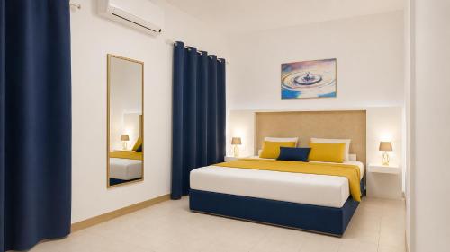 a bedroom with a bed with yellow and blue pillows at Oasi Park Hotel in Mascali