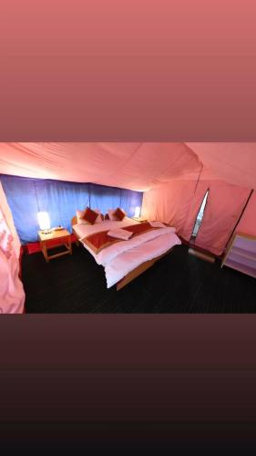 a bedroom with two beds in a tent at Saser Camp in Nubra
