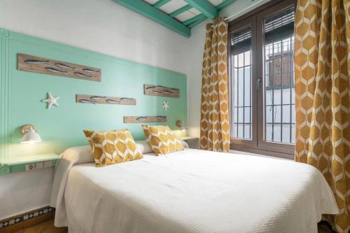a bedroom with a white bed and a window at Hostal Santa Catalina in Conil de la Frontera