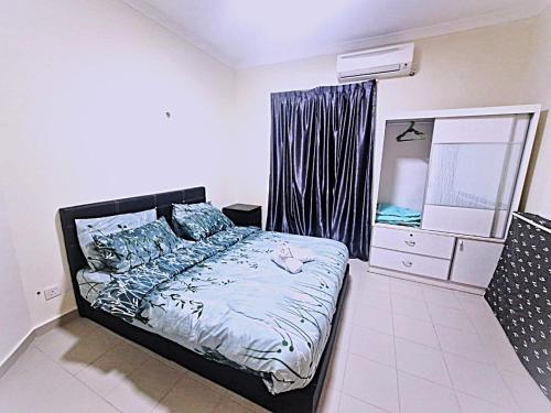 a bedroom with a bed and a dresser and a mirror at Desaru Coastline Cribs in Bandar Penawar