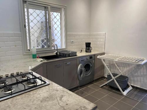 a kitchen with a stove and a washing machine at Chez Brahim in Ariana
