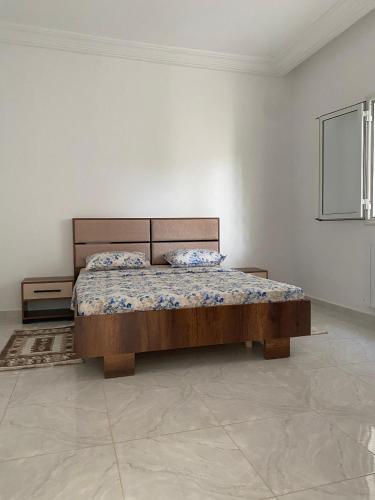 a bedroom with a bed in a white room at Chez Brahim in Ariana