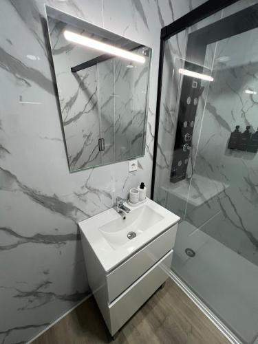 a white bathroom with a sink and a shower at Apartment in Amer in Amer