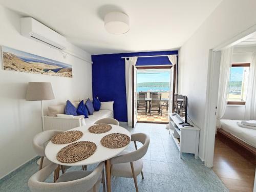 a living room with a table and chairs and a couch at Family Apartments Monika - sea view - heated pool in Punat