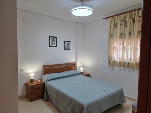 a bedroom with a bed and two night stands and two lamps at Holiday Costa marina 3MED006 in El Borseral
