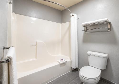 a bathroom with a white toilet and a bath tub at Hotel Blu in Columbia