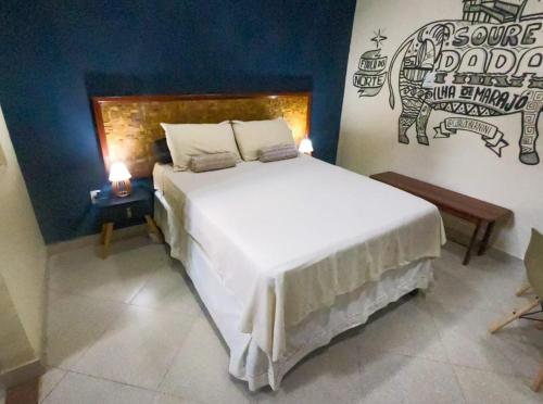 a bedroom with a white bed with a sign on the wall at Casa Marajoara in Soure
