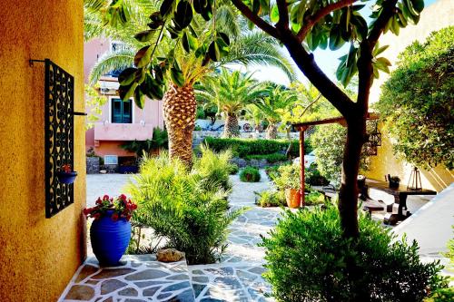 a garden with palm trees and vases on a patio at Vagia Traditional, Aegina Island in Vaia