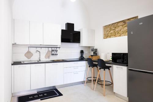a white kitchen with white cabinets and black appliances at La casina - YourPlace Abruzzo in Fossacesia